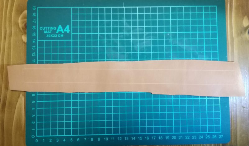 ストラップ式キーホルダーの裁断する線をひき終わる